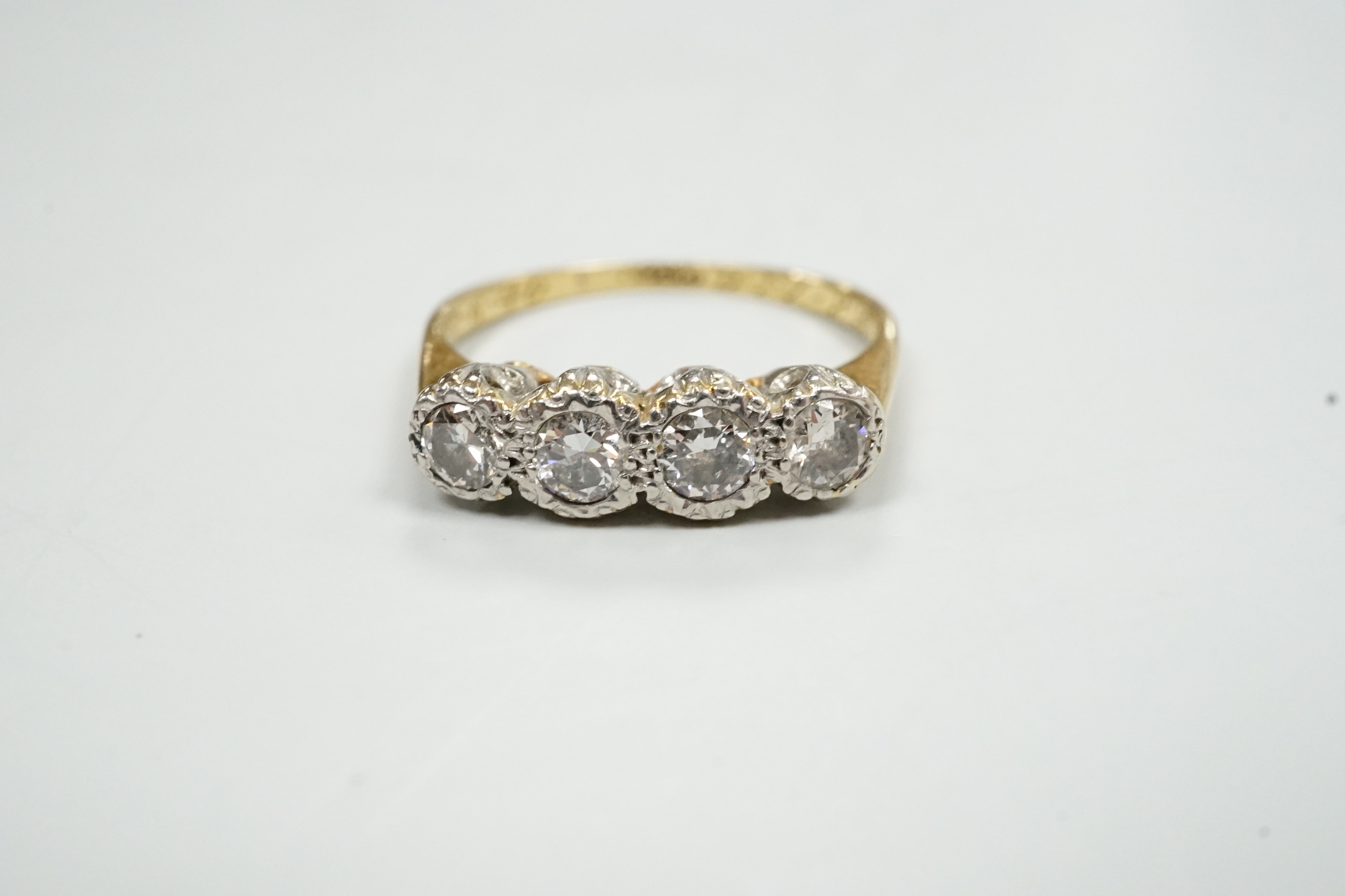 An 18ct, plat and four stone illusion set diamond ring, size M, gross weight 3.1 grams.